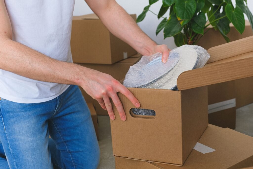 Movers packing kitchen items during relocation in Arabian ranches.