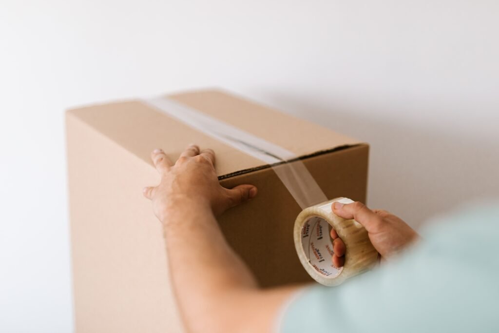 Professional packer securely wrapping household items for a move in Al Furjan