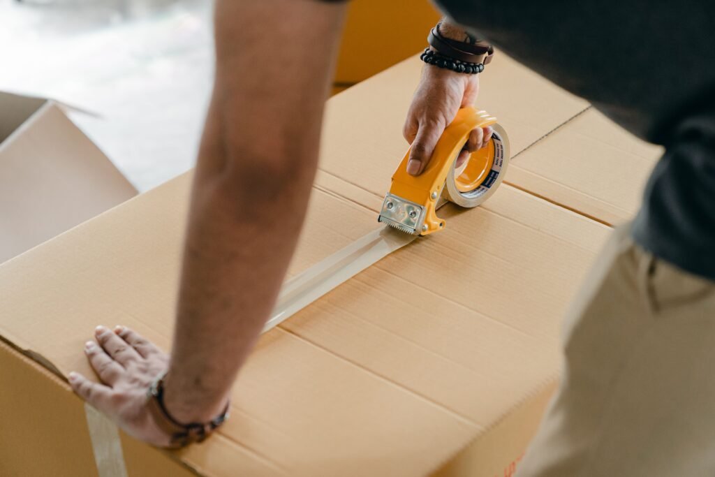 Professional packer securely wrapping household items for a move in Bur Dubai